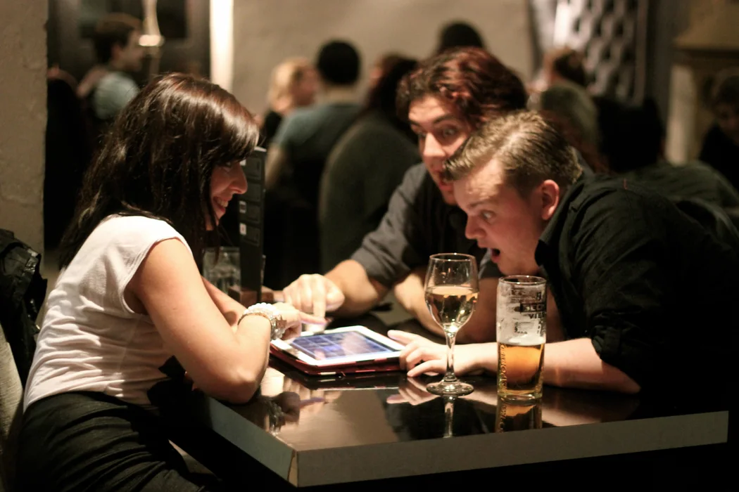 Players working together around a phone at a quiz